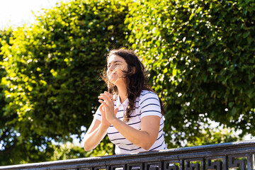 Middle-Aged Woman with Long Hair Smiling in City Park Greenery