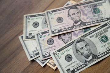 Us dollar bills. 5 dollar bills. Cash on a table. Concept of money, finance, economy, savings,...