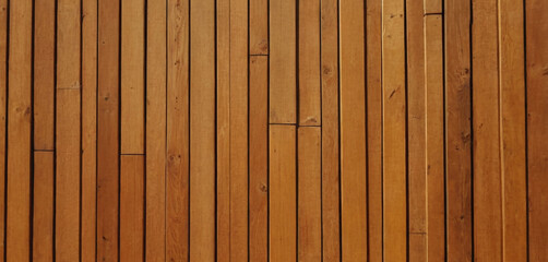 This image shows a close-up view of a wooden surface, characterized by horizontal planks with visible grains and textures. The wood has a dark brown color, and the lines between the planks are clearly