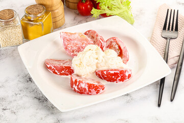 Salad with sliced tomato and stracciatella