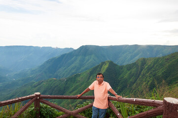 A tourist stood on the precipice of Laitlum Canyon in Meghalaya. Green hills in Meghalaya.