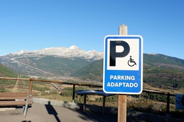 Parking sign reserved for disabled people in the National park of Pyrenees with the mountain view in Spain. Conceptual for infrastructure for people with disability
