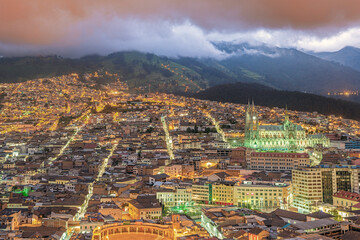 Bird eyes view at golden hour of the illuminated colonial center of Quito with the Basilique of the National Vow