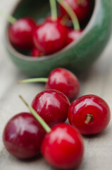closeup of freshly harvested sweet red cherry on rustic wood with selective focus