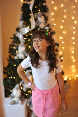 criança sorridente feliz em clima de natal, enfeites e decoração com luzes natalinas 