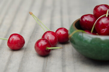 closeup of freshly harvested sweet red cherry on rustic wood with selective focus