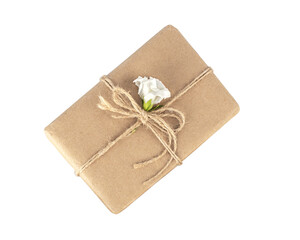 Gift box. Craft paper wrapped gift bandaged with jute rope, decorated with fresh flower, top view. Eco friendly and zero waste packaging.