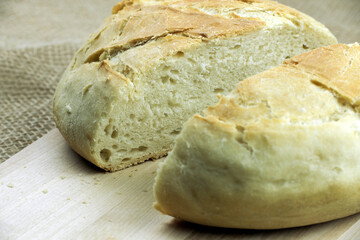 Freshly baked white bread from white flour, on a cutting board.