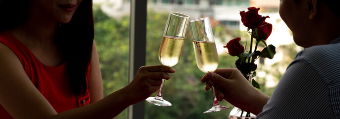 Silhouette couple hand toasting glasses of champagne celebrating on Anniversary, New Year, birthday...