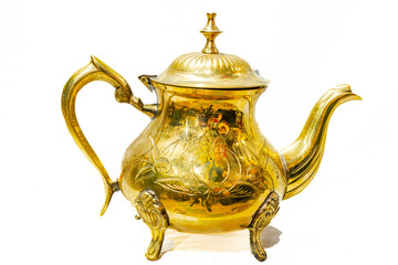 Vintage Brass Teapot decorated with a handcrafted design in relief with tree leaves shape. Reflective shining surface golden colored metal alloy. Studio shot isolated in white background. 