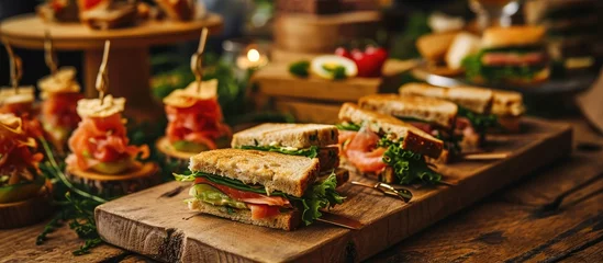 Foto op Plexiglas anti-reflex Tasty finger food spread with smoked salmon sandwiches, chicken and lettuce sandwich quarters. © AkuAku