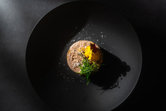 Vegane Foie Gras auf schwarzem Teller mit minimalem Licht