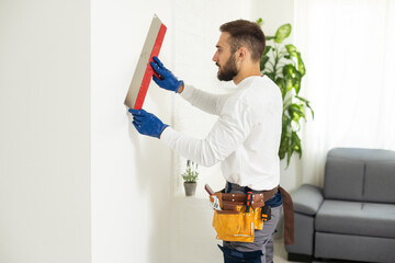 Construction worker are using sponge and plastering trowel to smooth the walls. Home improvement,...
