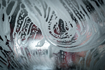 Close up shot of foam dripping from car, Car wash with high pressure washer.