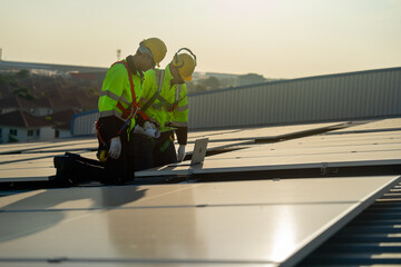 Caucasian technician workers look at laptop to check and maintenance solar cell panels on rooftop...