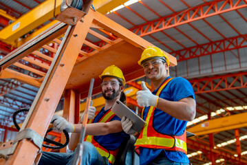 Two Caucasian factory worker show thumbs up and look at camera with one sit in truck and other stand beside with smiling in factory workplace area. - obrazy, fototapety, plakaty