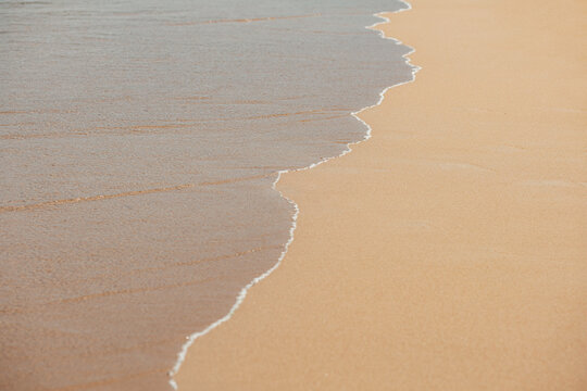 Gentle waves washing onto a sandy beach shore