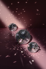 Three shiny disco balls indoors, color toned. Space for text