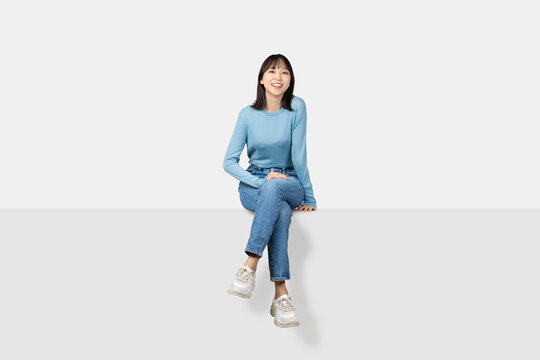 足を組んで腰掛ける笑顔の女性