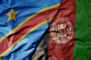 big waving national colorful flag of afghanistan and national flag of democratic republic of the...