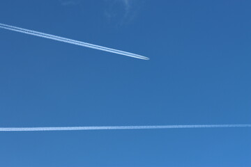Airplane with contrails in the deep blue sky