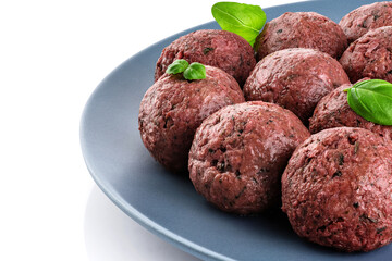 Raw vegan meatballs with basil leaves on a plate.
