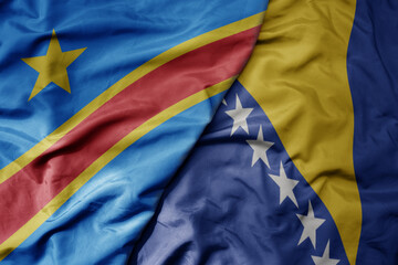big waving national colorful flag of bosnia and herzegovina and national flag of democratic...