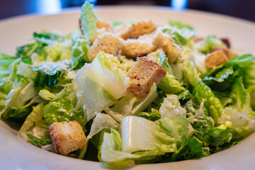 Close up of a delicious bowl of Caesar salad with lettuce, cheese and croutons 
