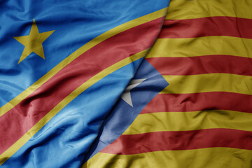 big waving national colorful flag of catalonia and national flag of democratic republic of the congo .