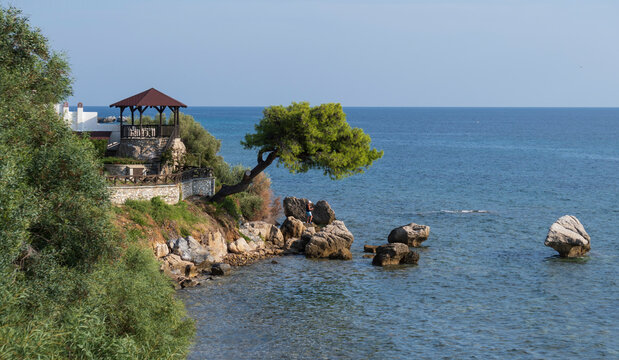 Beautiful view of the Aegean Sea through the rocky shore of the old Greek village of Loutra at sunset