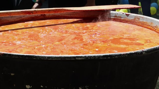 Tomato soup with pasta is a dish of Polish cuisine. Hot Zupa pomidorowa in a large cauldron at the field kitchen at a food fair. A popular soup made from grated tomatoes in their own juice.