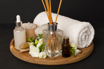 Spa composition with freesia flower and aroma diffuser on concrete background