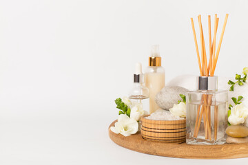 Spa composition with freesia flower and aroma diffuser on white background