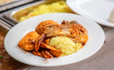Local jollof and fried rice, moi moi, and fish served at a party in Lagos