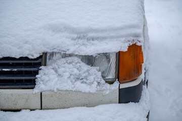 Car headlight closeup. Detail of the old car exterior. Old car headlight. Car covered with snow