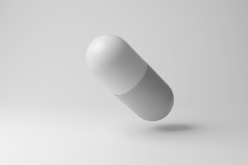 White antibiotic capsule floating in mid air on white background in monochrome and minimalism. Illustration of the concept of medicine and pharmaceutical industry