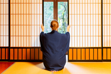 Traditional japanese house or ryokan with gaijin caucasian woman in kimono and tabi socks opening...