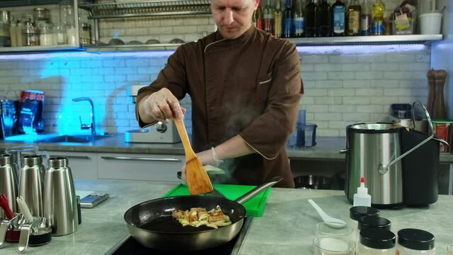 Cook decides that meat completely ready for further processing. Chef slides all ingredients with spatula to edge of pan and turns off hob