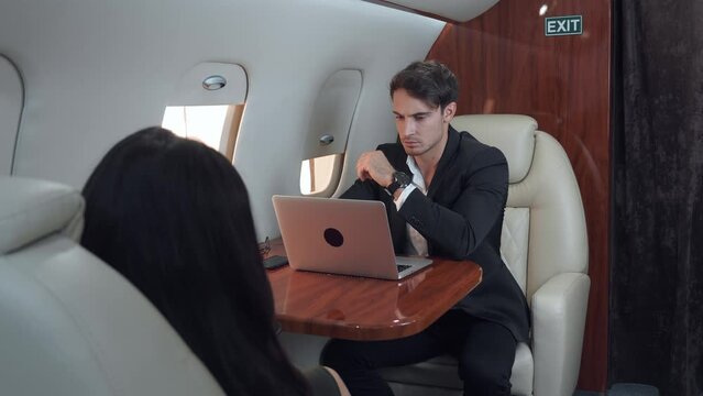 Elegantly dressed man works on laptop during luxurious flight work on laptop sign of successful modern career. Achieving happiness and freedom through work on laptop high above the clouds.