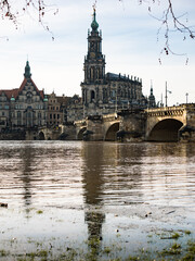 Obraz premium Dresden Hofkirche building as part of the famous old town. The Elbe river is flooding the embankment with a lot of thawing water. Extreme weather is causing chaos in the German city.
