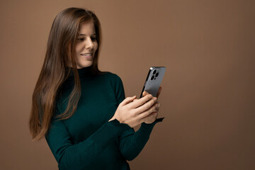 Confident young Caucasian woman with long brown hair chatting on a smartphone