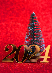 Decorative inscription 2024 and New Year tree on a red background, selective focus