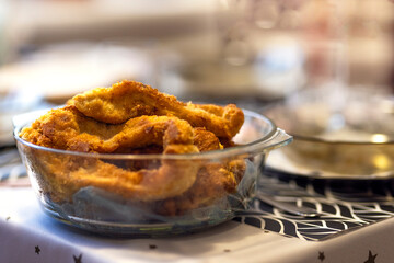 Homemade organic crispy fried fish in batter in a glass bowl on the table. Baked natural pieces of...