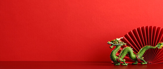 Chinese New Year 2024 banner design with dragon and paper folding fan decoration on red background.