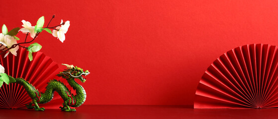 Chinese New Year 2024 banner with dragon, sakura flowers, paper cut fan on red background. © photoguns