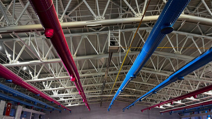 Coloured ventilation pipes on the roof of the indoor sports hall.