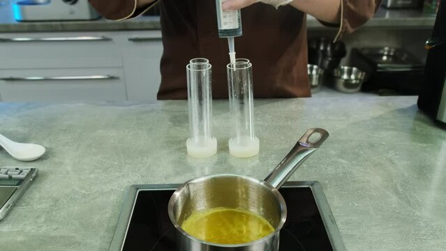 Experienced cook tries on pastry tube attachment suitable for filling mold with mixture. Process of preparing for unusual serving of dish