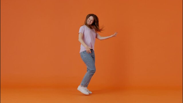 Female imitating playing guitar while jumping in studio