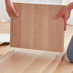 Woman assembling self-assembling furniture.Concept for self-contained, easy furniture assembly.