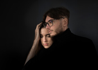 Fototapeta premium Portrait of a young couple on a black background.